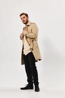 Mann im Beige Mantel modern Stil Mode aussehen beiseite foto