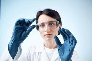Frau mit Blau Handschuhe Prüfung Forschung Analyse Diagnose foto