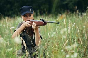 Frau auf Natur ein Schutz mit ein Waffe sieht aus in das Umfang Grün Blätter foto