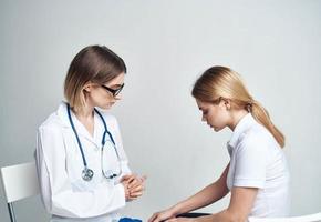 Arzt sitzt auf ein Stuhl und ein Frau geduldig drinnen auf ein Licht Hintergrund foto