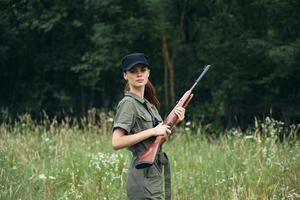 Frau auf Natur mit Waffen im Hand, ein schwarz Deckel ist ein Lebensstil Grün Overall foto