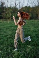 ein sportlich Frau läuft und Züge ihr Körper Vor das Sommer- Jahreszeit im das Park foto