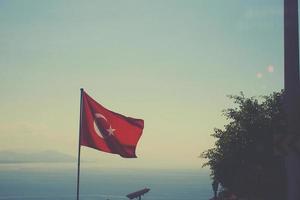 Türkisch Flagge winken im das Wind auf ein Sommer- warm Tag gegen das Himmel foto