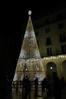 golden glühend Weihnachten Baum Dekoration auf schwarz Hintergrund alicante Spanien im Vorderseite von das Stadt, Dorf Halle foto