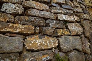 Mauer Hintergrund mit ein alt uralt Stein Struktur Nahansicht foto