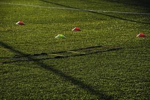 Ausbildung Fußball Tonhöhe mit künstlich Grün Gras und Ausbildung AIDS beleuchtet durch das Nachmittag Sonne foto