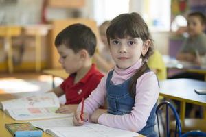 Kinder im ein Zeichnung Lektion im Kindergarten. Kinder im Vorschulalter mit Bleistifte und Färbung sind Sitzung beim das Tische. foto