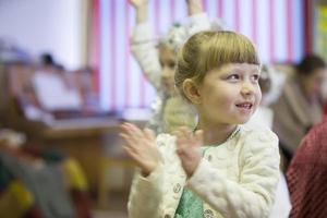 froh Mädchen klatscht ihr Hände beim ein Kinder- Party. foto