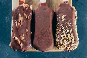 Eskimo Eis Sahne auf Stock im Schokolade Glasur auf Blau Hintergrund. lecker Süss Essen Snack behandeln foto