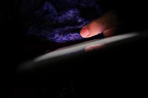 Nahaufnahme der Hand, die Smartphone nachts hält foto