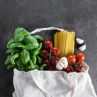 gesund Produkt zum Italienisch Pasta im Stoff Tasche auf dunkel Tisch. wiederverwendbar Tasche mit Lebensmittel. foto