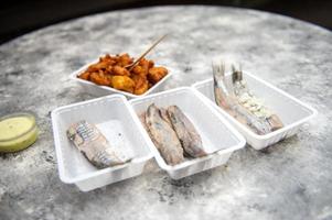 Essen von ein Fisch Restaurant im Holland. Hering mit Zwiebeln. angeschlagen Fisch im ein Container foto
