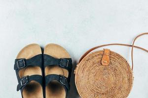 beiläufig Damen Sommer- Sandalen und modisch organisch Rattan Tasche. Urlaub, Reise Konzept. oben Aussicht foto