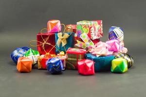 Nahaufnahmestapel der Geschenkboxen, die durch buntes Papier eingewickelt werden foto