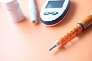 Insulinpens auf orangefarbenem Hintergrund foto