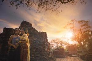 zwei asiatisch Frau tragen thailändisch Tradition Kleider Stehen im alt Tempel von Ayutthaya Welt Erbe Seite? ˅ von UNESCO zentral von Thailand foto