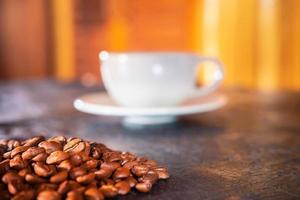 Kaffeetassen und Kaffeebohnen auf einem hölzernen Hintergrund foto