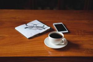 Kaffee, Notizbuch und Telefon foto