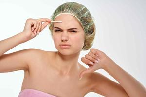 Frau mit nackt Schultern Pickel auf ihr Stirn Reinigung Gesicht foto