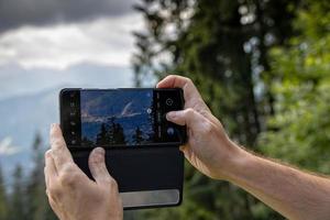 nehmen ein Foto während Ferien im das Berge mit Ihre Smartphone