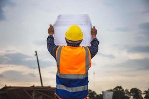 bauingenieur, der projekt auf der baustelle überprüft, architekt mit bauplänen auf einer baustelle, vorarbeiter in helm auf der infrastrukturbaustelle foto