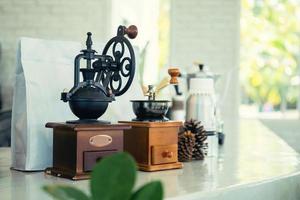 Kaffee Schleifer mit Kaffee Bohnen Tasche und alt Kaffee Mühle auf das Kaffee Geschäft Bar Zähler foto