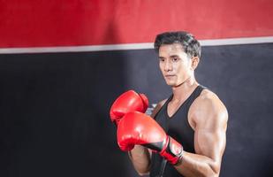 Porträt von stark jung Athlet Sportler muay thailändisch Boxer Kampf im Fitnessstudio, muskulös gut aussehend Boxen Mann Kämpfer mit Kopieren Raum foto