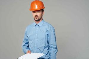 Mann im Konstruktion Uniform Blaupausen Baumeister Licht Hintergrund foto