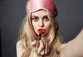 sexy blond Frau mit rot Lippenstift Emotionen und Rosa Maske auf ihr Gesicht foto