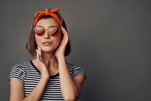 ziemlich Frau tragen Sonnenbrille posieren Mode im modern Stil foto