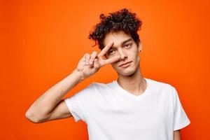 Kerl mit lockig Haar Gesten mit seine Hand Emotionen modern Stil foto