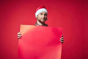 gut aussehend Mann im Neu Jahre Kleider Werbung Kopieren Raum rot Hintergrund foto
