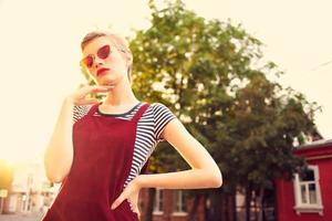 heiter Frau im Sonnenbrille draußen Sommer- gehen Mode foto