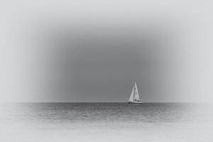 Sommer- Landschaft von das baltisch Meer mit Blau Wasser und Himmel und ein Weiß Segelboot foto