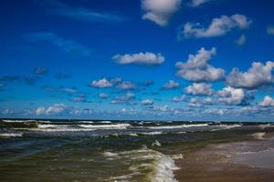 sonnig Tag auf das Ufer von das Polieren baltisch Meer mit Blau Himmel und Wasser Wellen foto