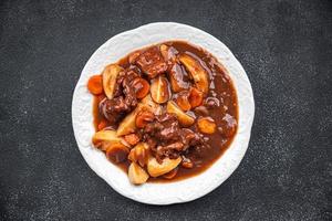 Rindfleisch Bourguignon Fleisch Gericht mit Gemüse bereit zu Essen gesund Mahlzeit Essen Snack auf das Tabelle Kopieren Raum Essen Hintergrund rustikal foto