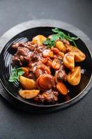 Rindfleisch Bourguignon Fleisch Gericht mit Gemüse bereit zu Essen gesund Mahlzeit Essen Snack auf das Tabelle Kopieren Raum Essen Hintergrund rustikal foto