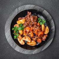 Rindfleisch Bourguignon Fleisch Gericht mit Gemüse bereit zu Essen gesund Mahlzeit Essen Snack auf das Tabelle Kopieren Raum Essen Hintergrund rustikal foto