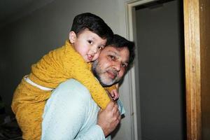 Porträt von großartig Papa Tragen Baby Junge beim heim. Ahmed Mustafain Haider ist posieren beim heim. ursprünglich er ist von Pakistan aber Leben beim Luton England Vereinigtes Königreich. Bild war gefangen auf 02. April 2023 foto