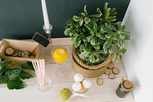 Waffel Kegel mit Weiß Eis Sahne im ein Glas Vase, Papier Röhren und ein Pflanze im ein Vase auf das Küche Tabelle oder im ein Cafe, oben Aussicht foto