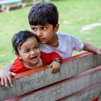 zwei glücklich Jungs im Gesellschaft Park, glücklich asiatisch Brüder Wer sind lächelnd glücklich zusammen. Brüder abspielen draußen im Sommer, Beste Freunde. Kleinkind Baby Junge spielen mit seine glücklich Bruder im das Garten foto