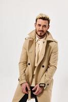Mann im Mantel selbst Vertrauen Mode modern Stil Licht Hintergrund foto