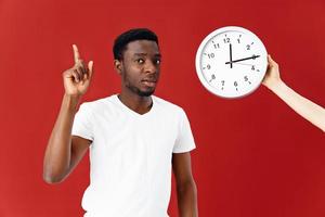 Mann von afrikanisch Aussehen im Weiß T-Shirt Uhr rot Hintergrund foto