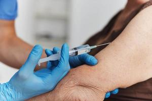 Arzt geben ein Injektion zu ein Frau Hand covid-19 Impfung Reisepass foto
