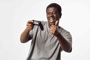 heiter Mann von afrikanisch Aussehen mit ein Joystick im seine Hände Theaterstücke Video Spiele foto