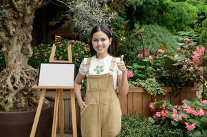 ein jung Frau ist lächelnd im ihr Blume Geschäft , klein Geschäft Konzept. foto