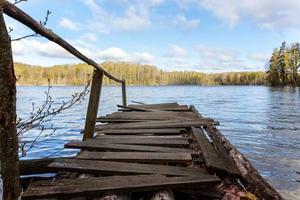 Waldsee oder Fluss am Sommertag und altes rustikales Holzdock oder Pier foto
