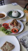Essen Portion Reis mit gebraten Hähnchen und Gemüse auf das Tabelle im ein Restaurant. foto