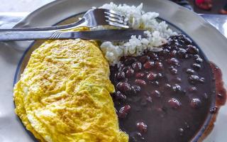 Mexikaner Omelett Eier schwarz Bohnen Reis Nachos auf Weiß Platte. foto