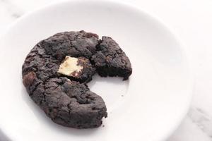 halb gegessener Schokoladenkeks auf einem Teller foto